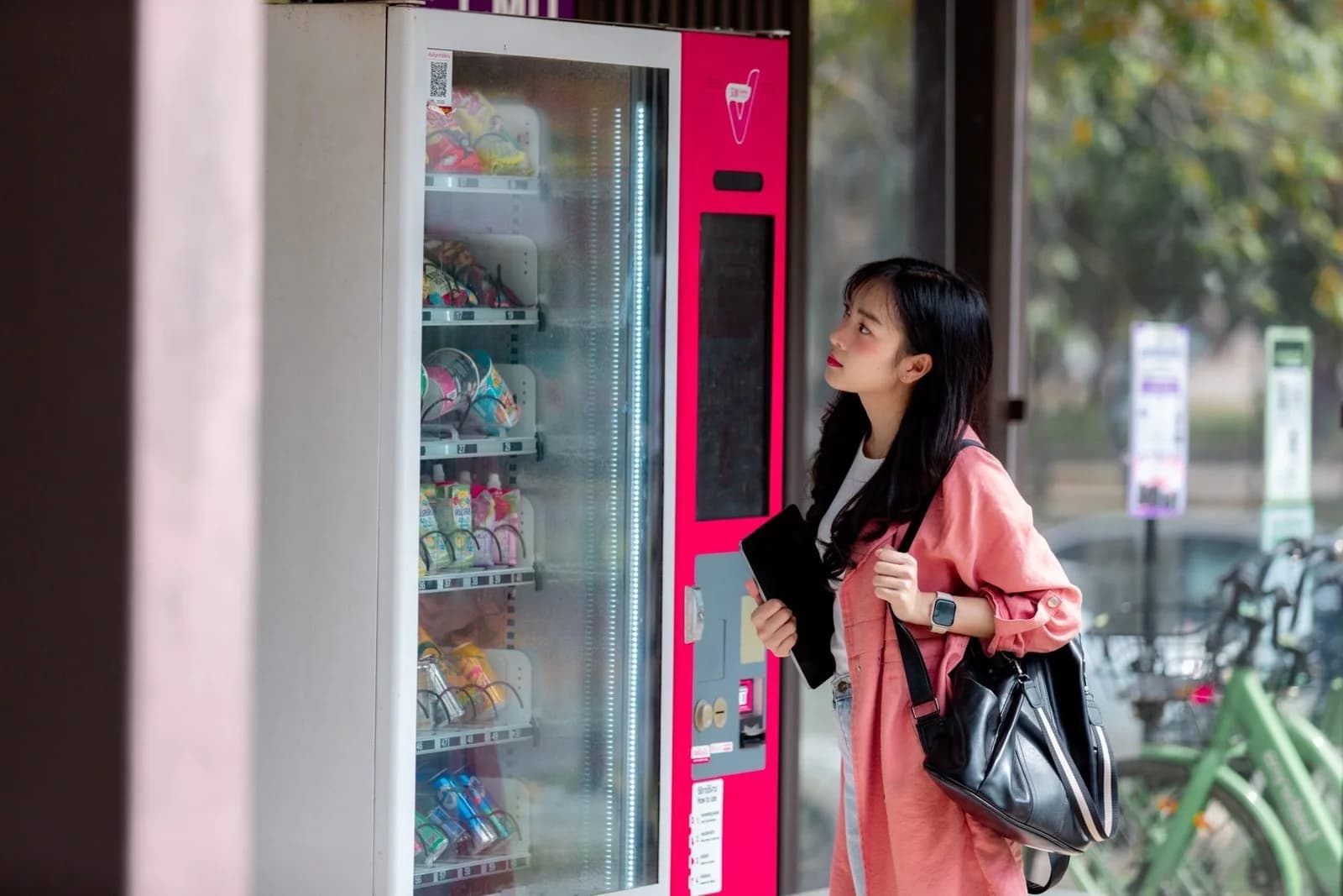 A person choosing snacks and drinks at a vending machine