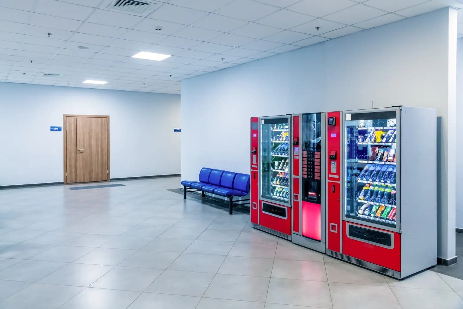 Two vending machines in a public building hallway