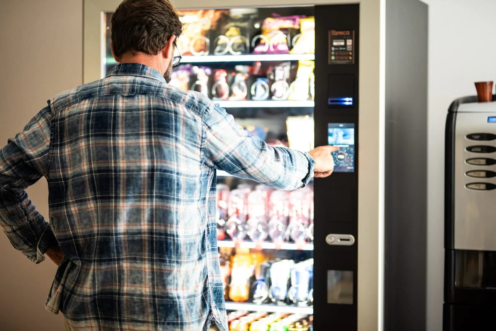 A man choosing snacks at a vending machine